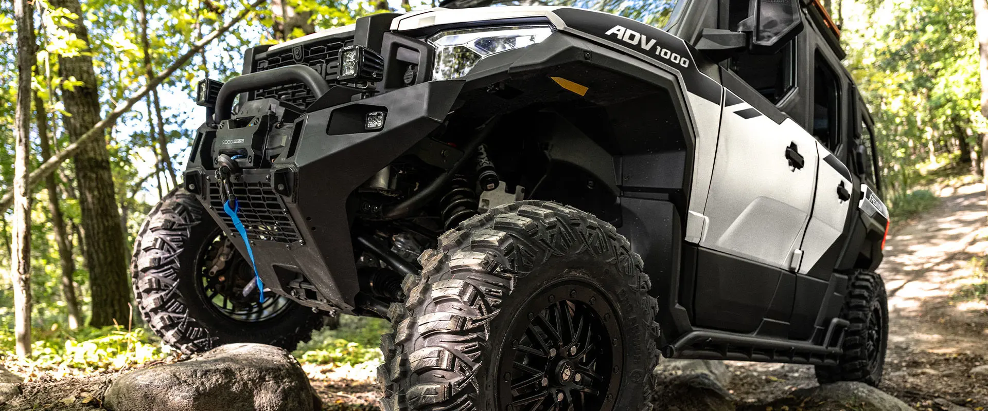 Closeup of the tires and shocks of a 2027 Polaris XPEDITION ADV 5 NorthStar side-by-side.