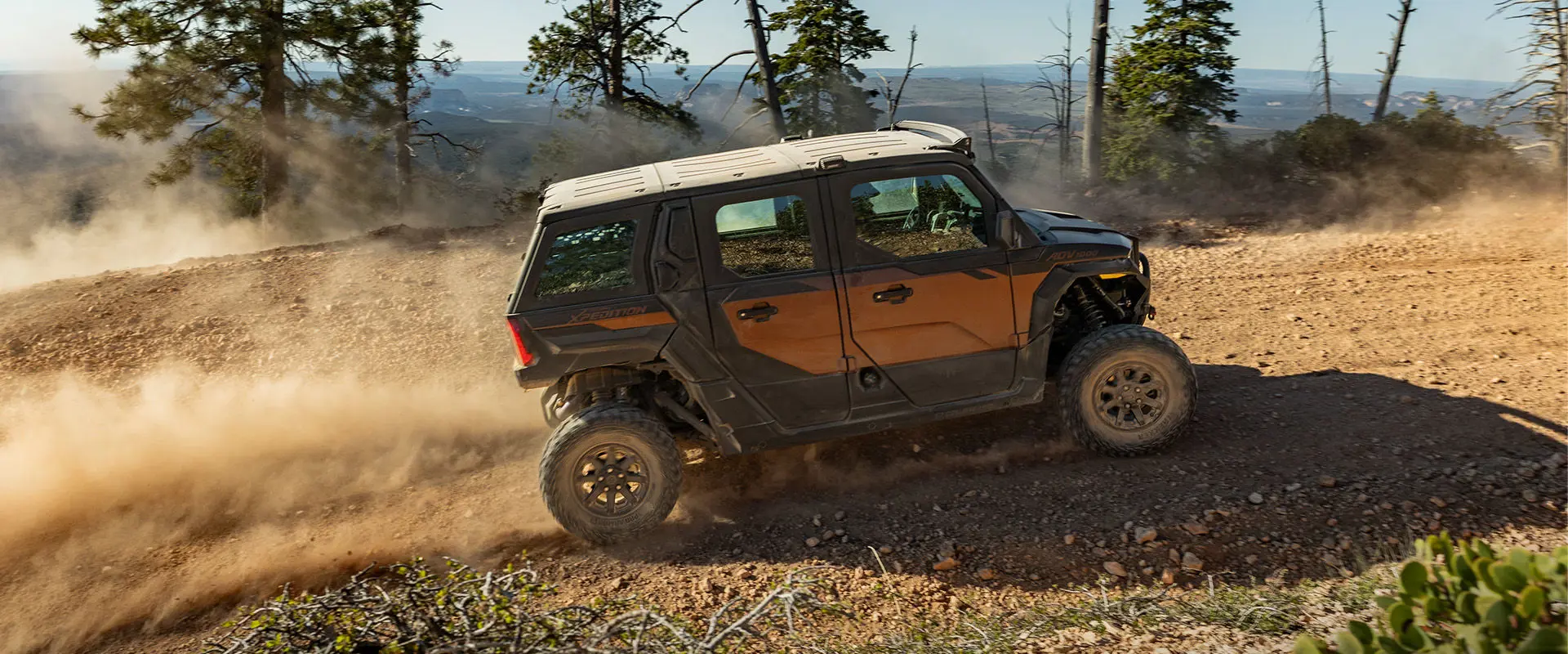 Side profile of a 2027 Polaris XPEDITION ADV 5 NorthStar side-by-side climbing up a dusty hill.