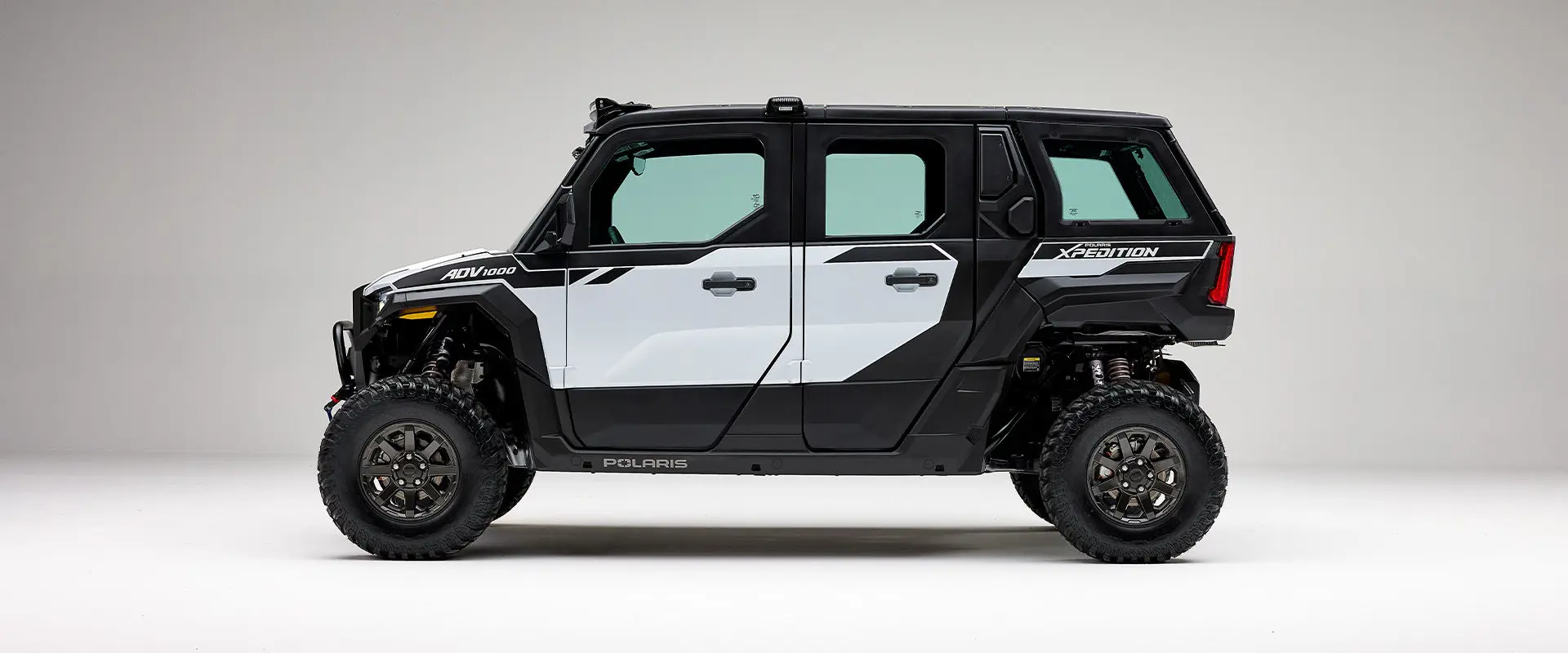 Side profile of a Ghost White Metallic 2027 Polaris XPEDITION ADV 5 NorthStar side-by-side.