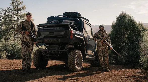 2 hunters walking away from a 2027 Polaris XPEDITION XP NorthStar side-by-side.
