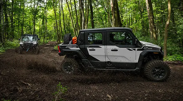 2 2027 Polaris XPEDITION XP NorthStar side-by-sides cruising down a forest trail.